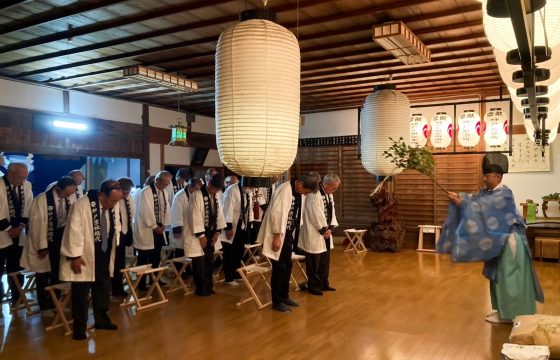 神社の建物の中で大勢がお祓いを受けている