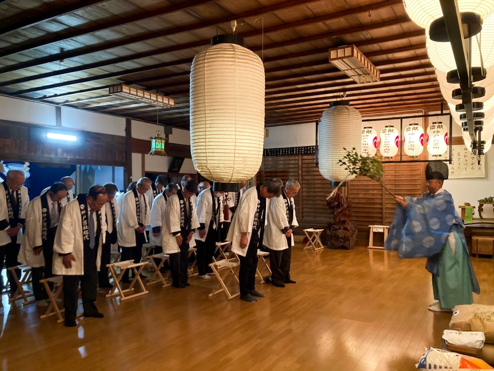 神社の建物の中で大勢がお祓いを受けている